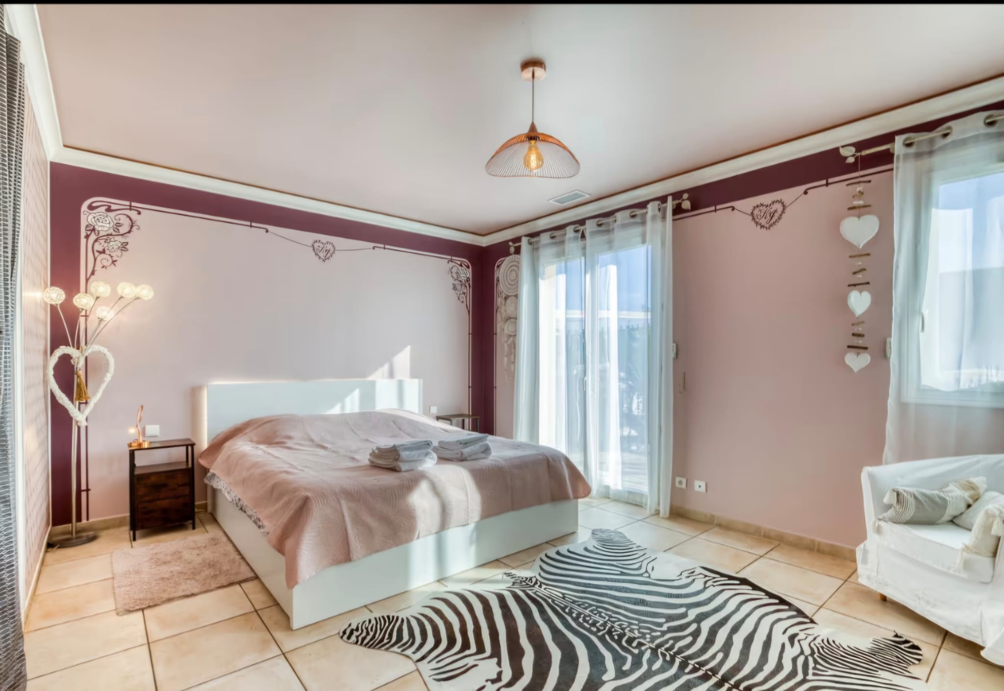 Chambre bordeaux avec lit double et tapis zébré