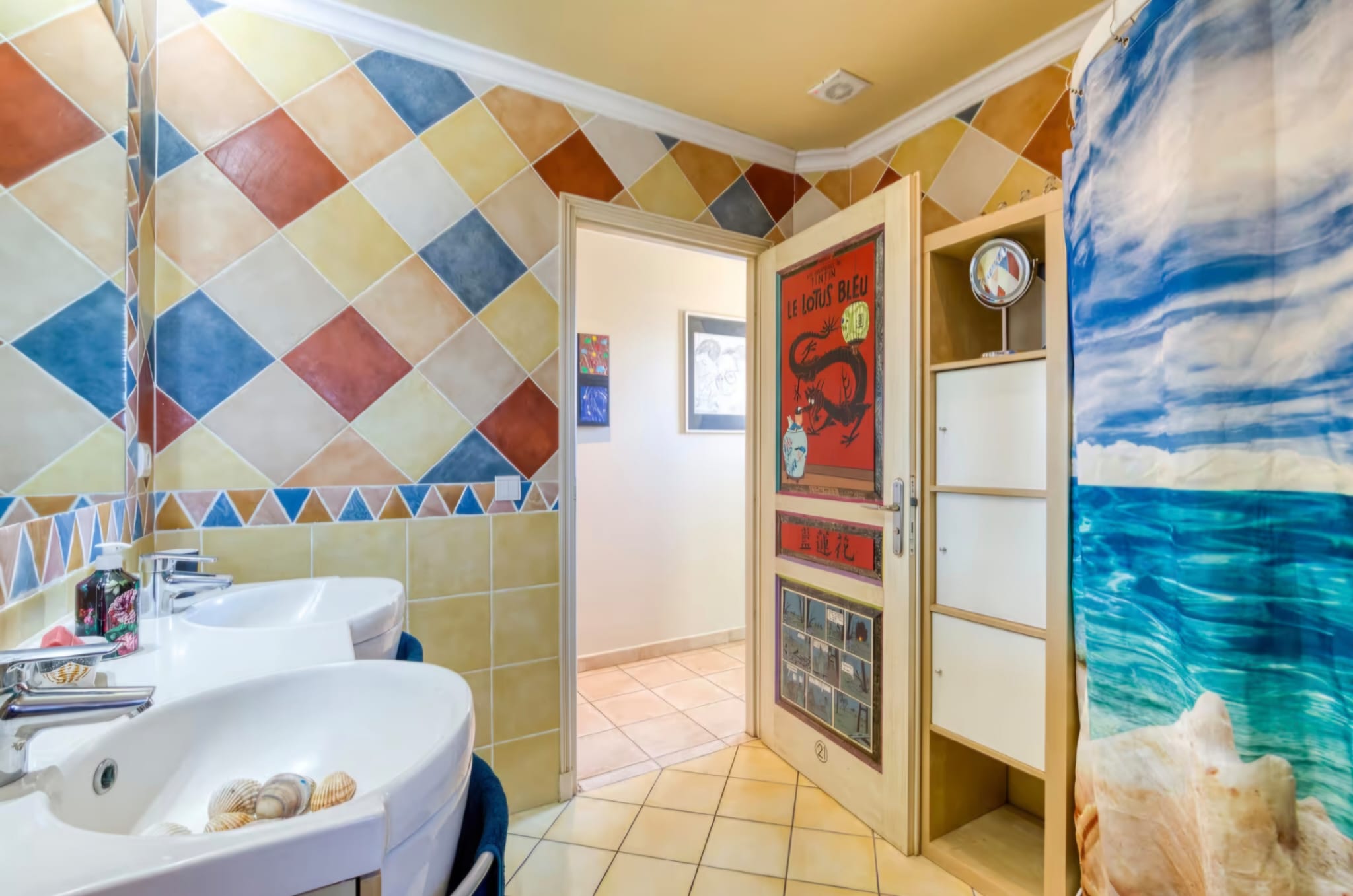 Salle d'eau aux carreaux colorés en losanges, porte Tintin « Le Lotus Bleu »