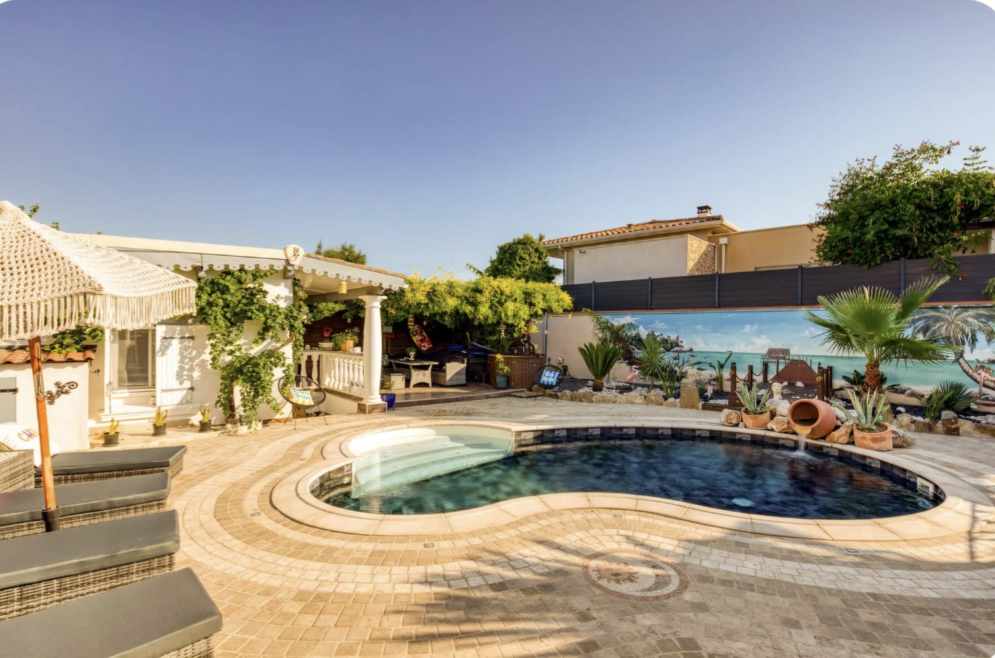 Piscine en forme de haricot avec pergola et fresque plage